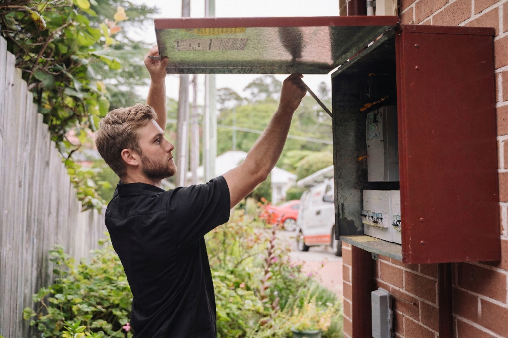 Electrician installing downlights in a Mona Vale home